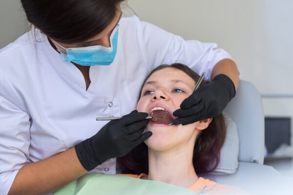 Close up dental treatment procedure in dental office. Dentistry, healthy teeth, medicine and healthcare concept